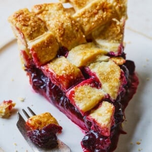 Slice of cherry pie with a lattice pie crust topping.