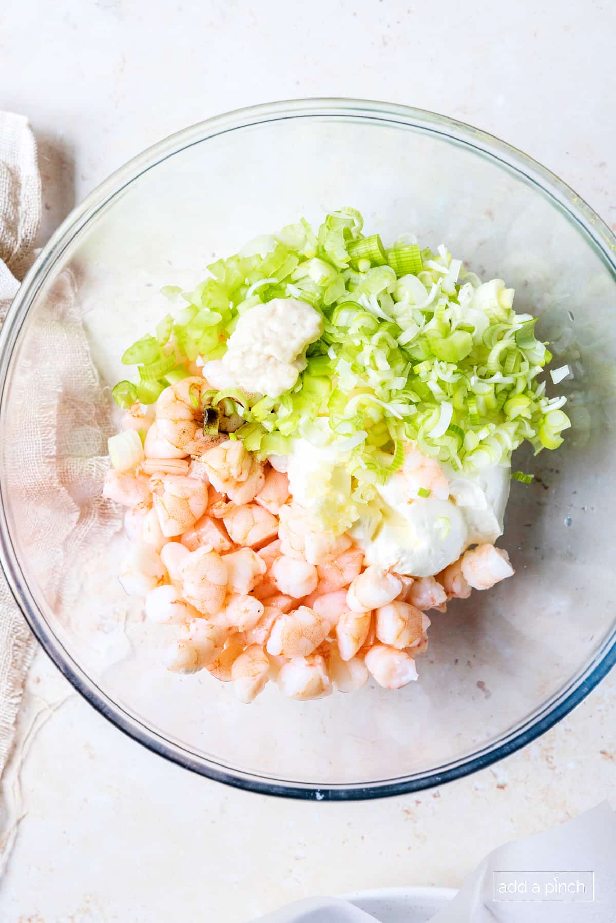 Shrimp Dip ingredients in a glass bowl on a white surface.