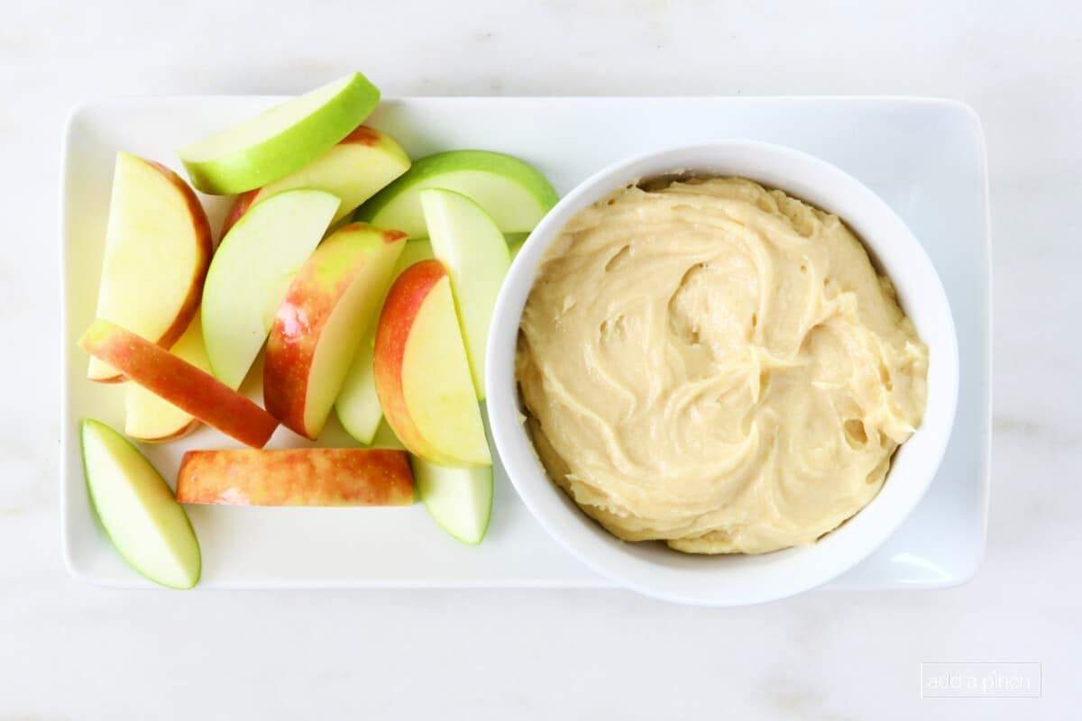 Serving tray and bowl holds red and green apple slices and creamy apple dip.