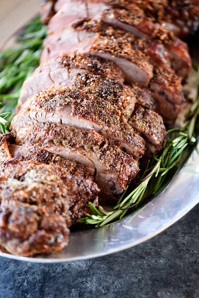 Pewter platter with sliced Beef Tenderloin surrounded by fresh rosemary.