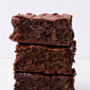 Stack of the best brownies on a marble countertop with a white background.