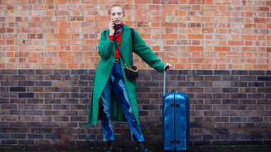 woman with colourful blue luggage 2024