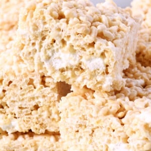 Stack of rice krispie treats on a white platter.