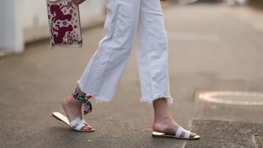 Yasmin von Schlieffen-Nannen wearing Mother white denim jeans, Hermes linen mini clutch, Hermes white leather sandals and ancle scarf on March 24, 2022 in Hamburg, Germany.