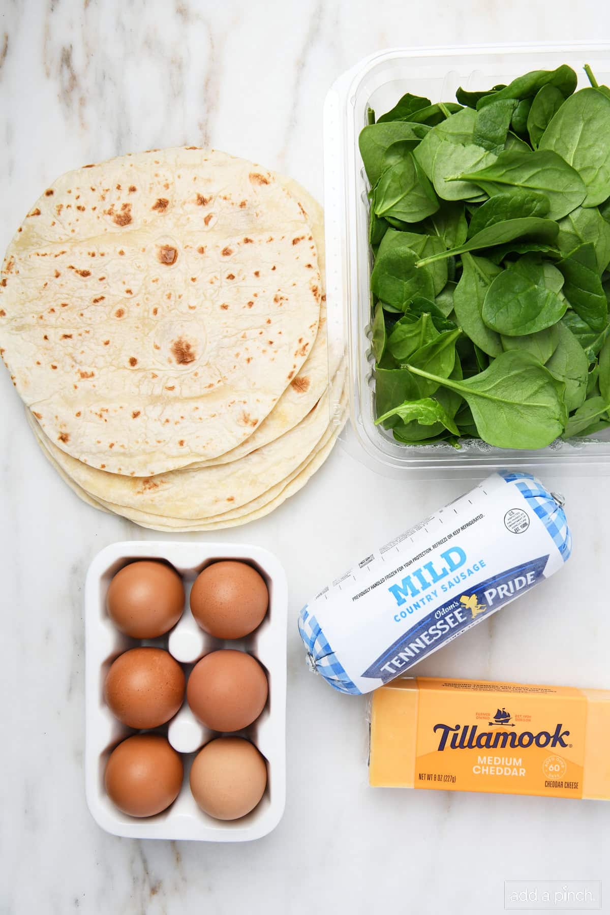 Ingredients used to make breakfast burritos on a marble surface.