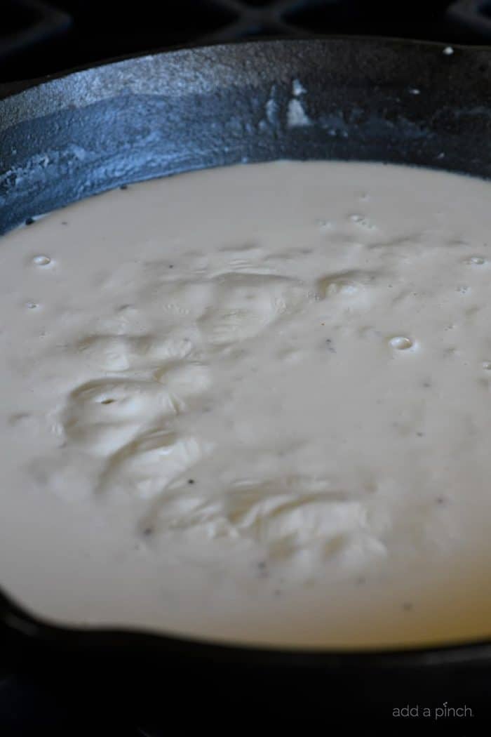 Homemade cheese sauce bubbling in skillet.