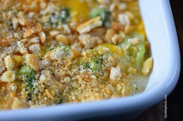 Broccoli cheese casserole in a white casserole dish ready to be baked. 