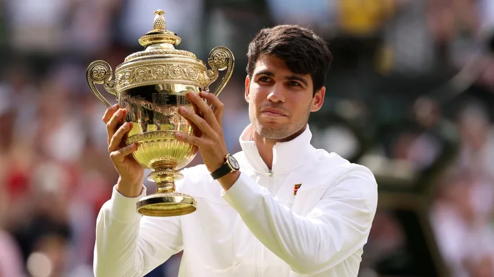 Carlos Alcaraz of Spain poses with the Gentlemen's Singles Trophy following victory against Novak Djokovic of Serbia in the Gentlemen's Singles Final during day fourteen of The Championships Wimbledon 2024 at All England Lawn Tennis and Croquet Club on July 14, 2024 in London, England.