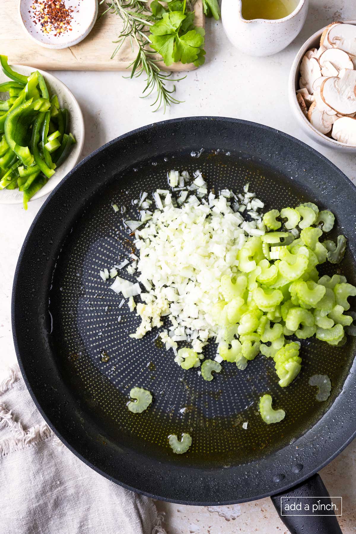 Sauteing onions, garlic, and celery in a skillet.