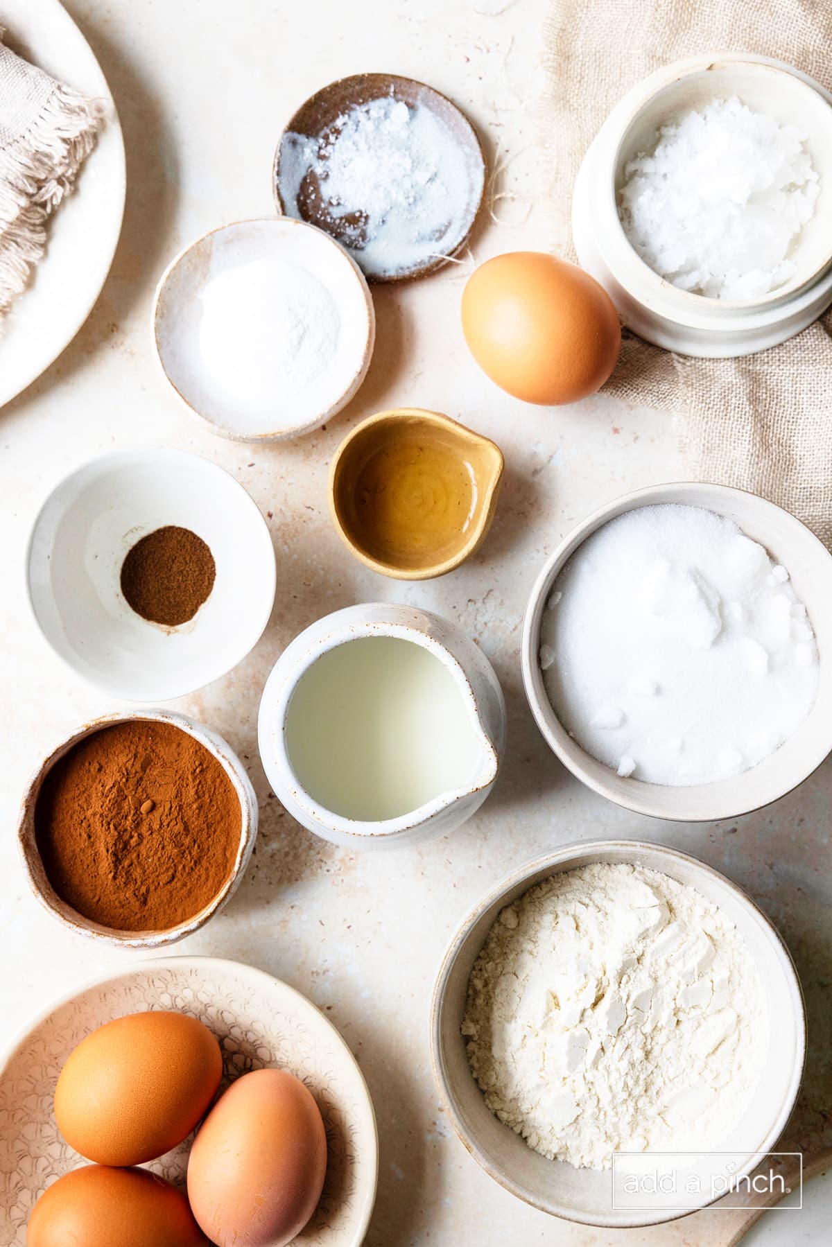 Ingredients to make a chocolate cake roll on a white background.