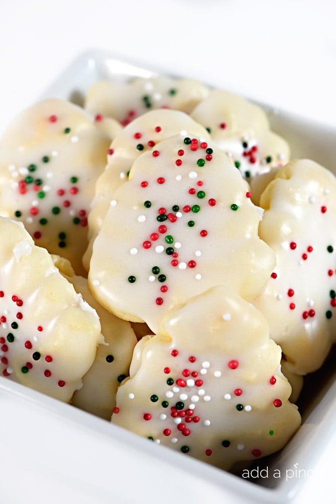 Stack of glazed Spritz cookies with red, green, and white sprinkles 