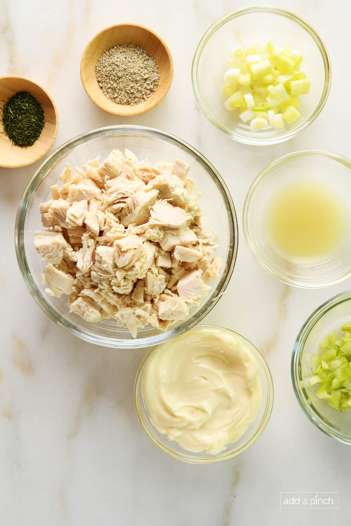 Photo of ingredients to make classic chicken salad recipe on a marble surface.