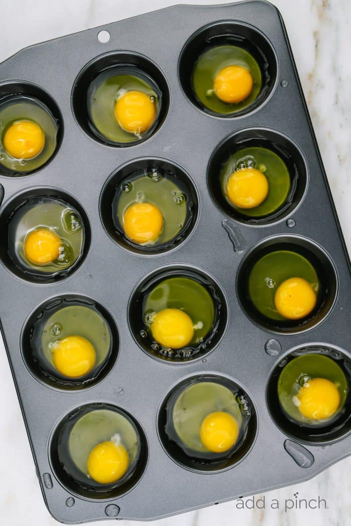 Muffin tin with each hole holding a raw egg. 