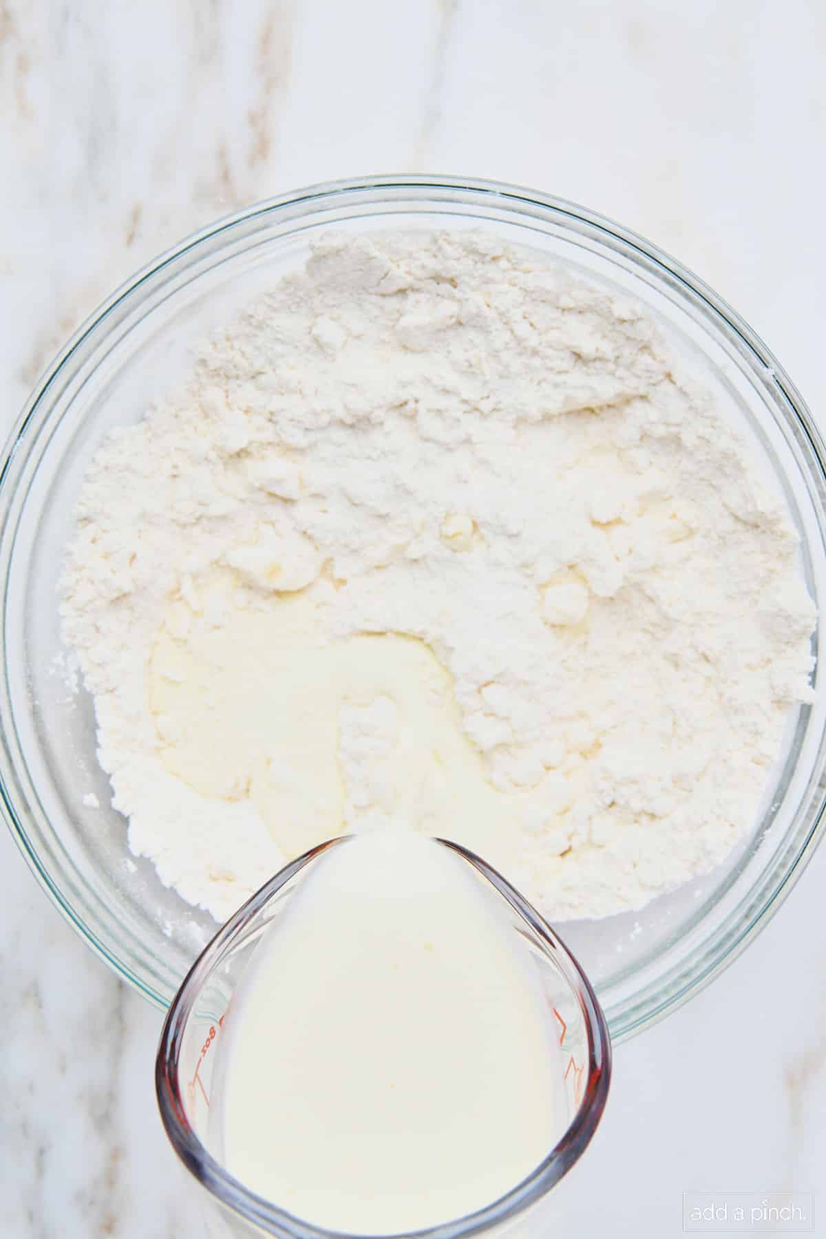 Cream being poured into dry ingredients for easy scones recipe.