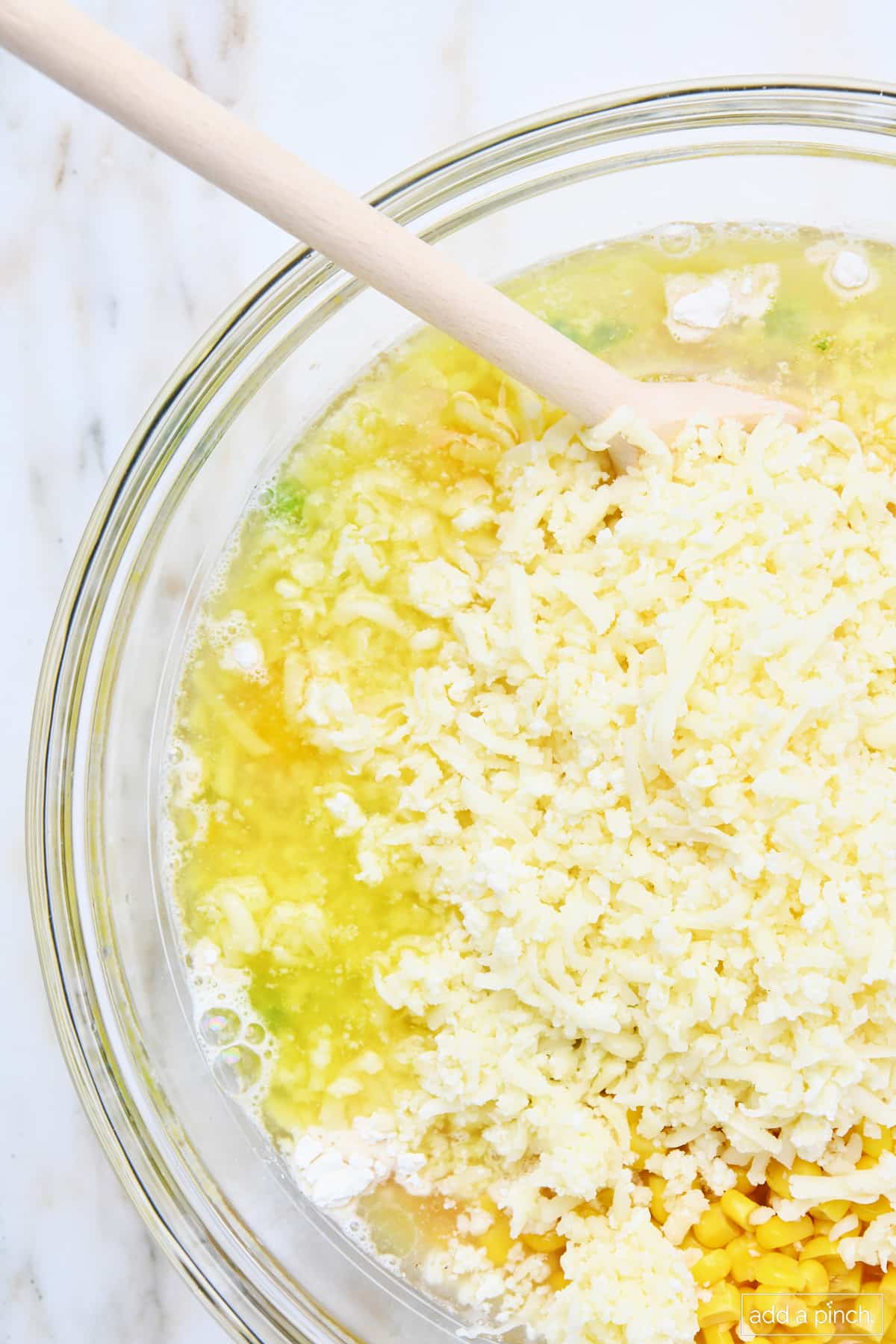 Ingredients for corn casserole in a glass mixing bowl.