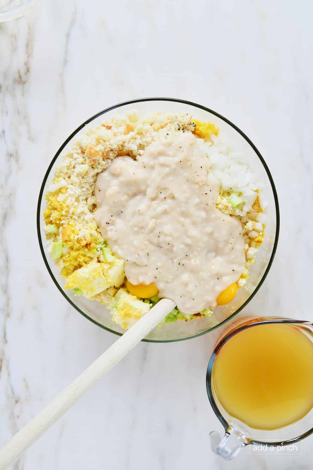 Cream of chicken soup added to mixture in a glass bowl.