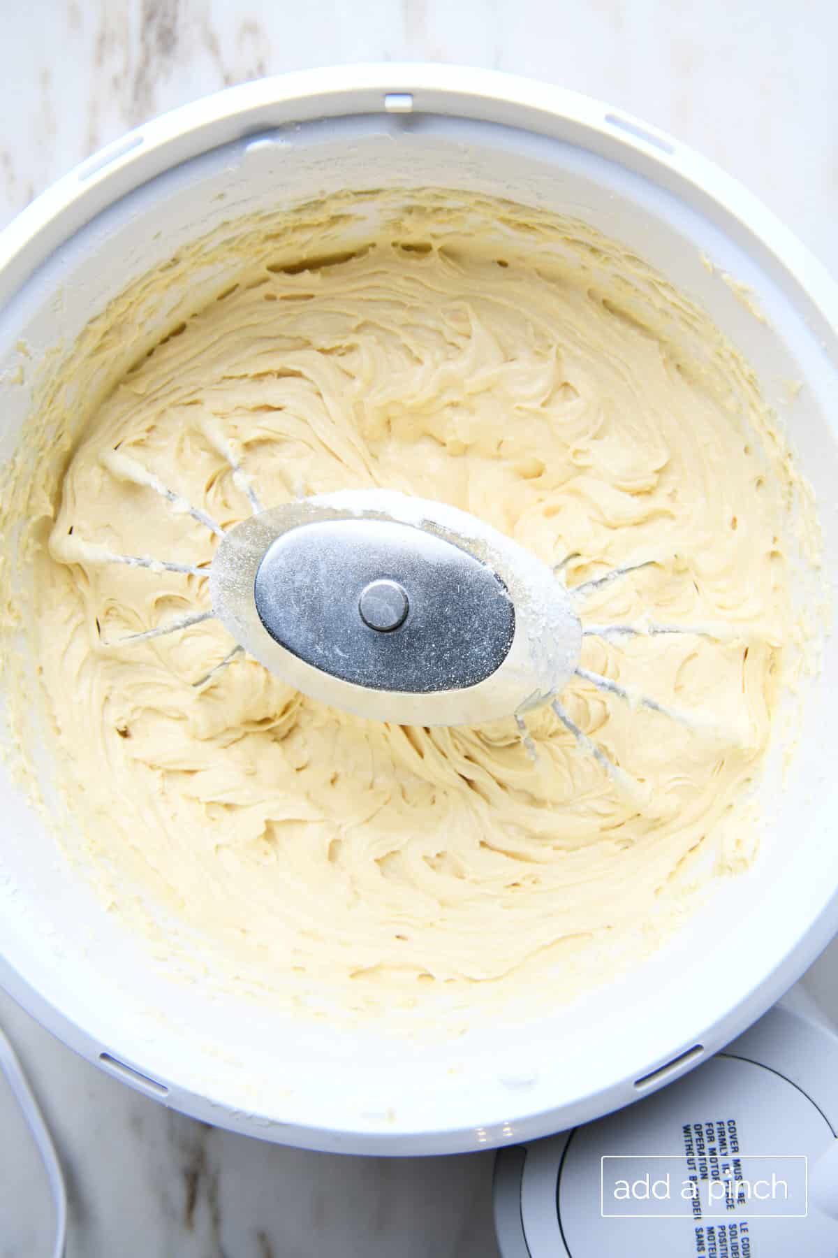 Smooth pound cake batter in a stand mixer bowl after it's been blended. 