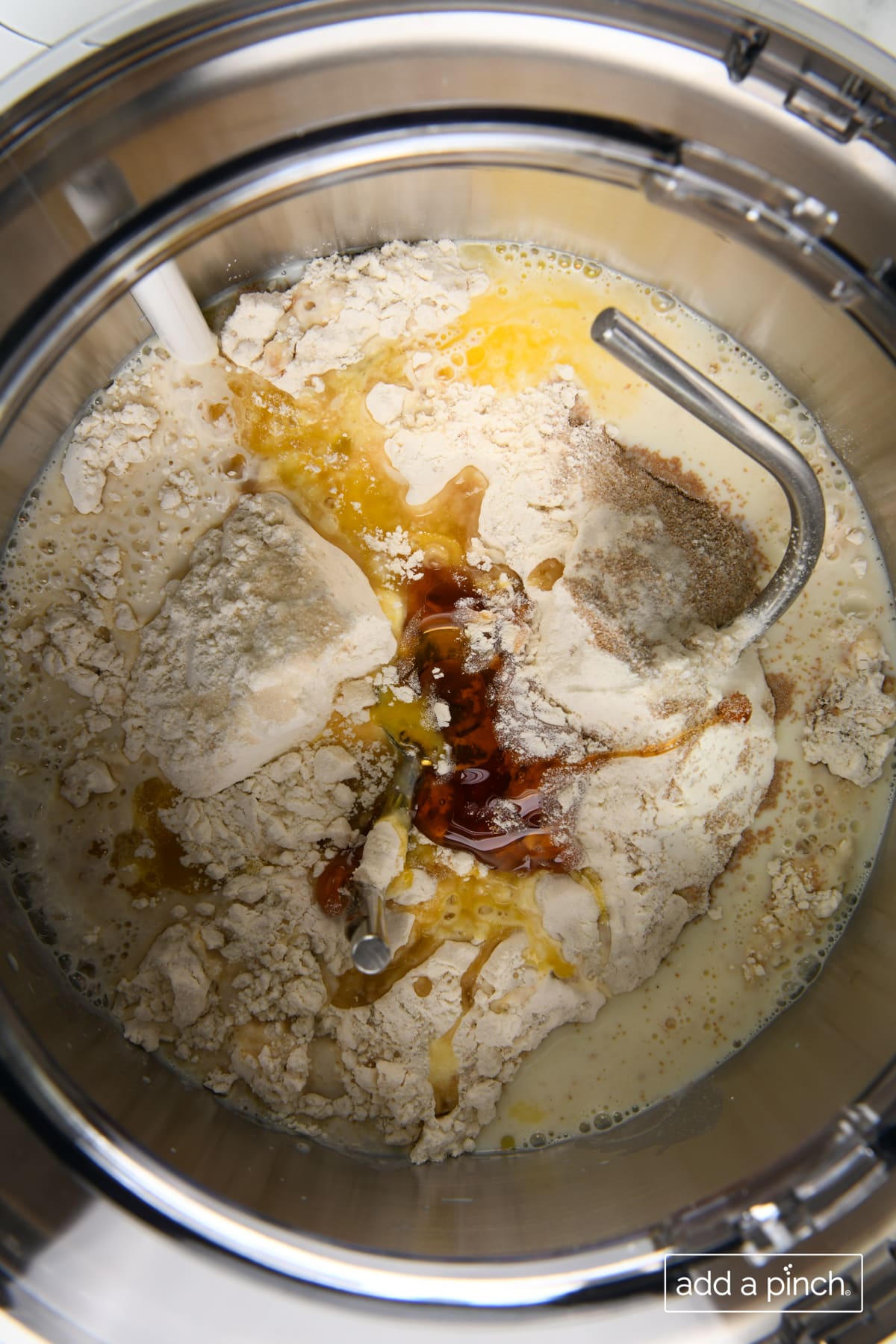 Ingredients to make dough for dinner rolls in a stand mixer.