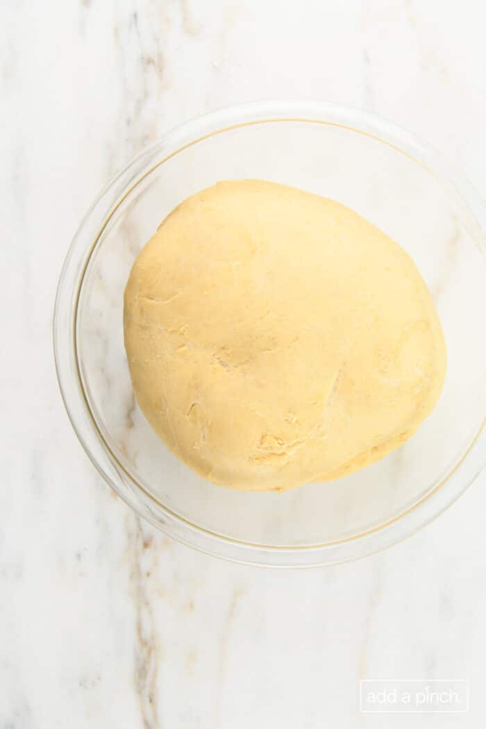 Risen dough in a glass bowl.