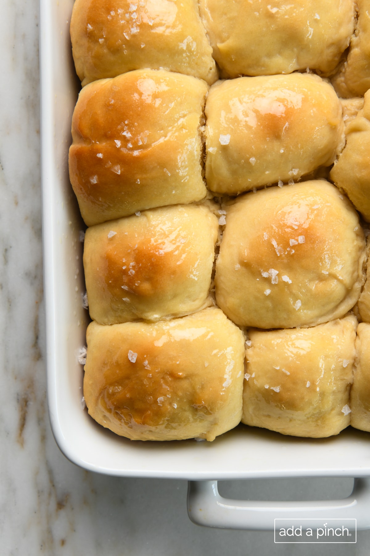 Baked dinner rolls brushed with butter and sprinkled with salt.