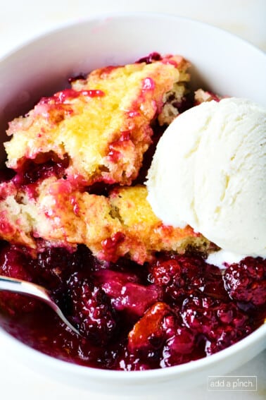 Blackberry cobbler with vanilla ice cream in a white bowl