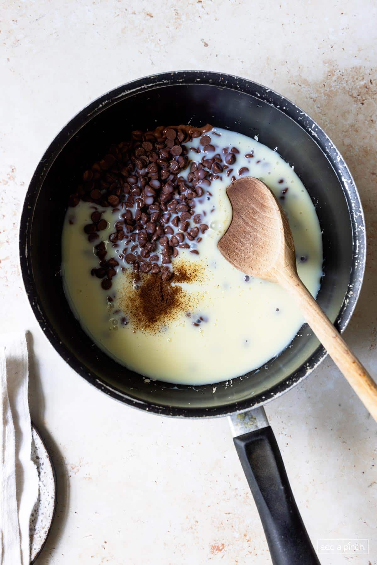 Saucepan with ingredients for making fudge on the stovetop.