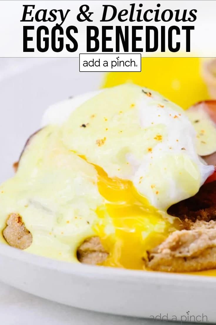 Eggs Benedict showing poached egg with bit of runny yolk on top of english muffin, drizzled with Hollandaise sauce - with text - addapinch.com