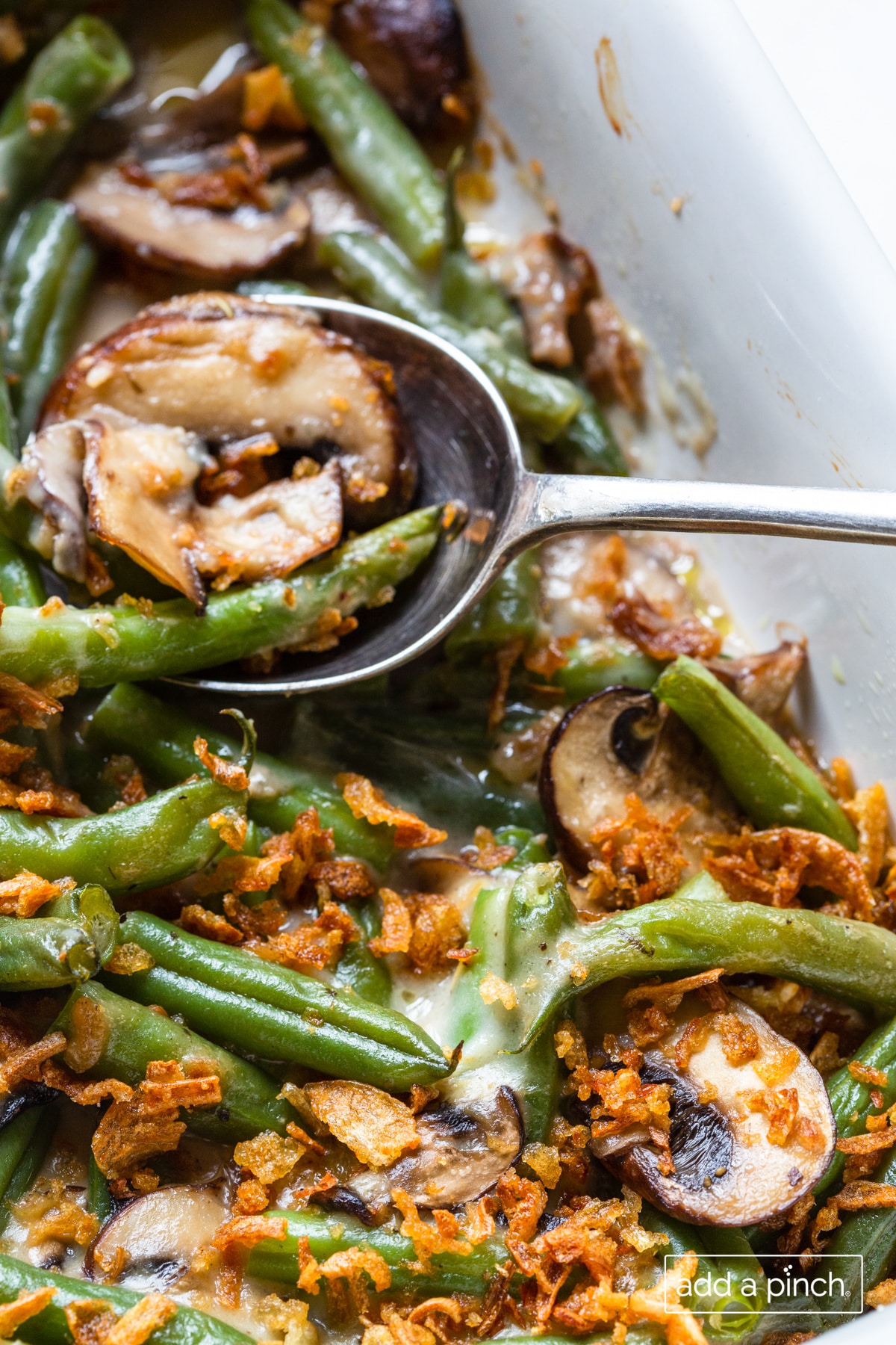 Photo of green bean casserole in a white baking dish.