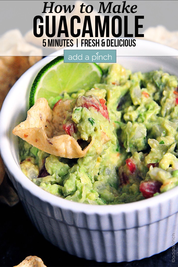 Fresh Guacamole with chip and a lime slice in a white bowl - with text - addapinch.com