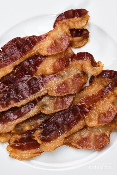 Photo of bacon on a white plate.