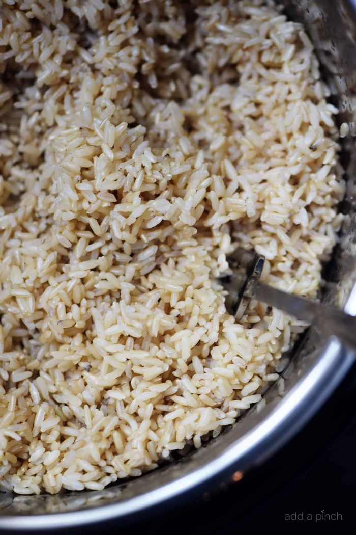 Fork fluffing brown rice as it rests.