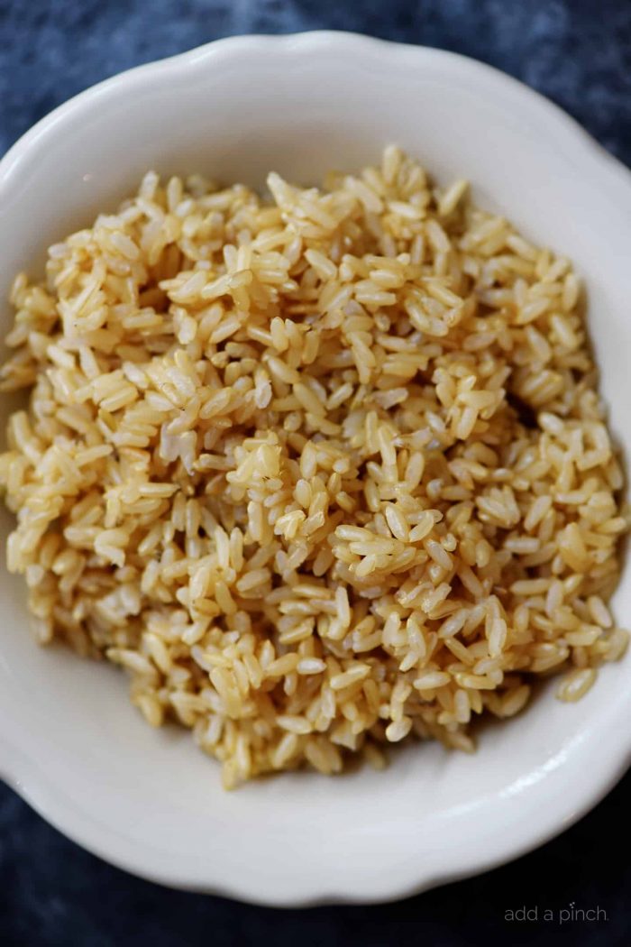 Cooked brown rice in a white bowl.