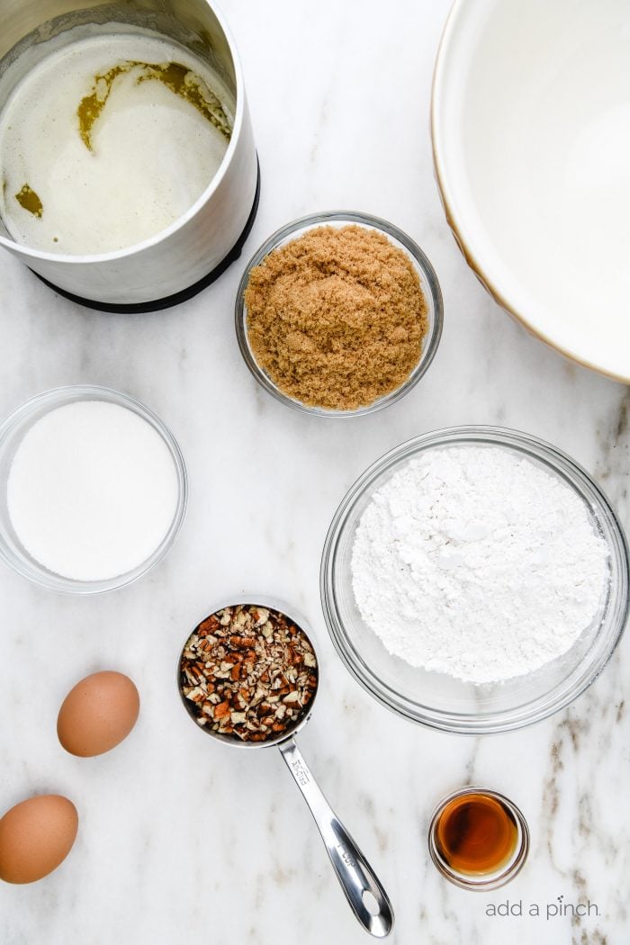 Ingredients measured out into glass bowls and a stainless measuring cup to make Pecan Chewies // addapinch.com