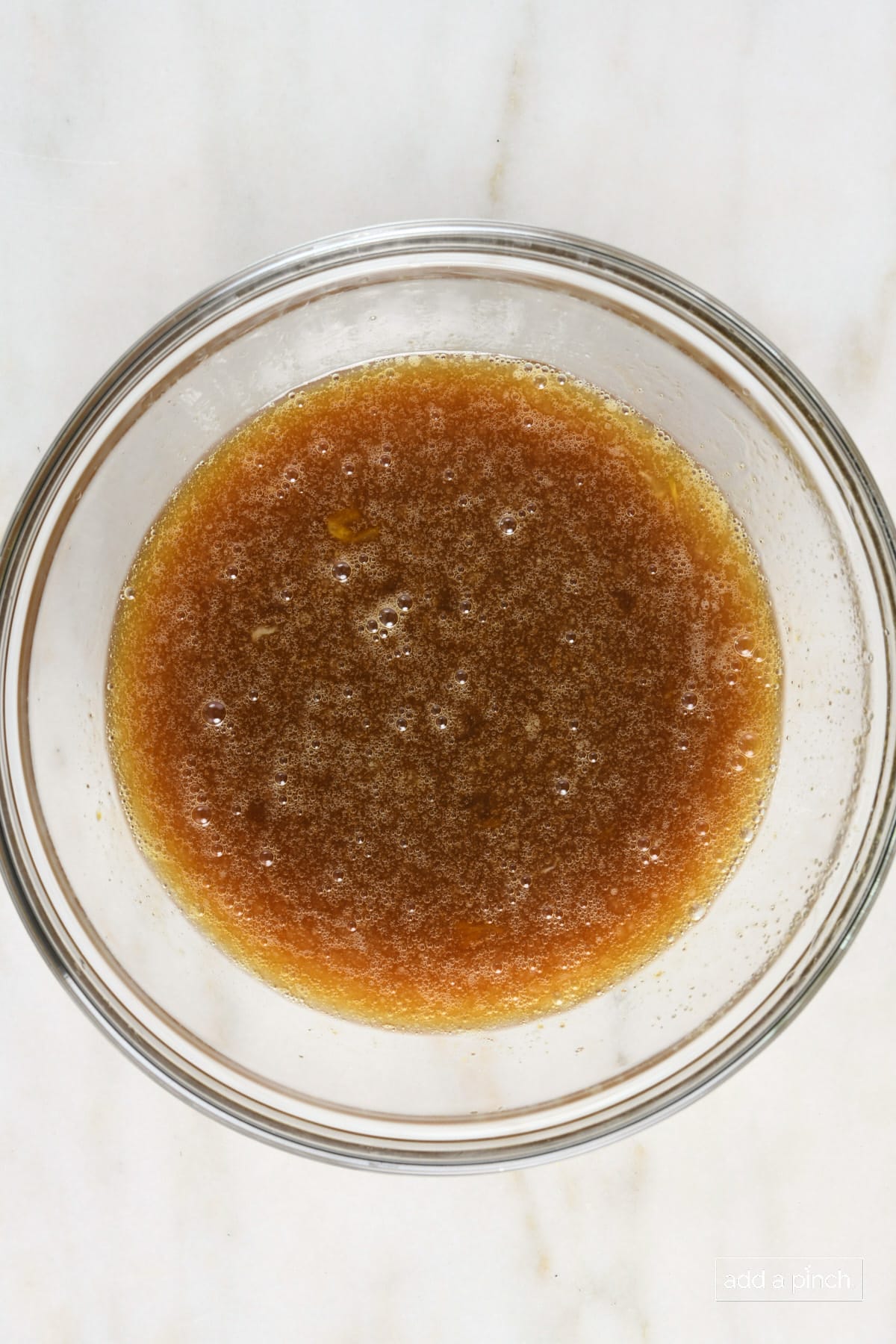 Mixing bowl that has liquid pecan pie filing ingredients mixed together. 