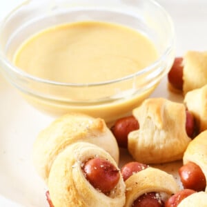 Platter of pigs in a blanket appetizer with honey dijon dipping sauce.