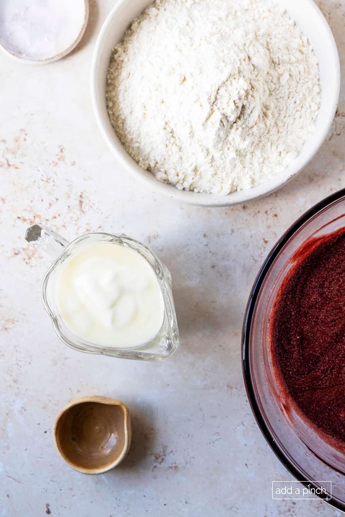 Overhead photograph of dry ingredients and buttermilk ready to be combined with wet ingredients for red velvet cake.