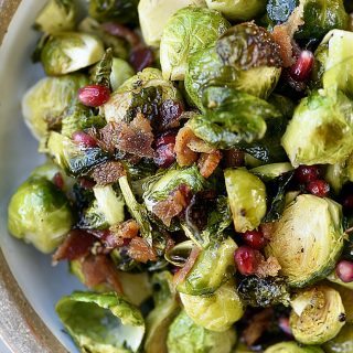 Roasted Brussels Sprouts with Pomegranate and Bacon Recipe - Roasted Brussels Sprouts with Pomegranate and Bacon make a delicious side dish! The brussels sprouts are roasted and then drizzled with maple syrup and balsamic vinegar and then tossed with crispy bacon and pomegranate! // addapinch.com