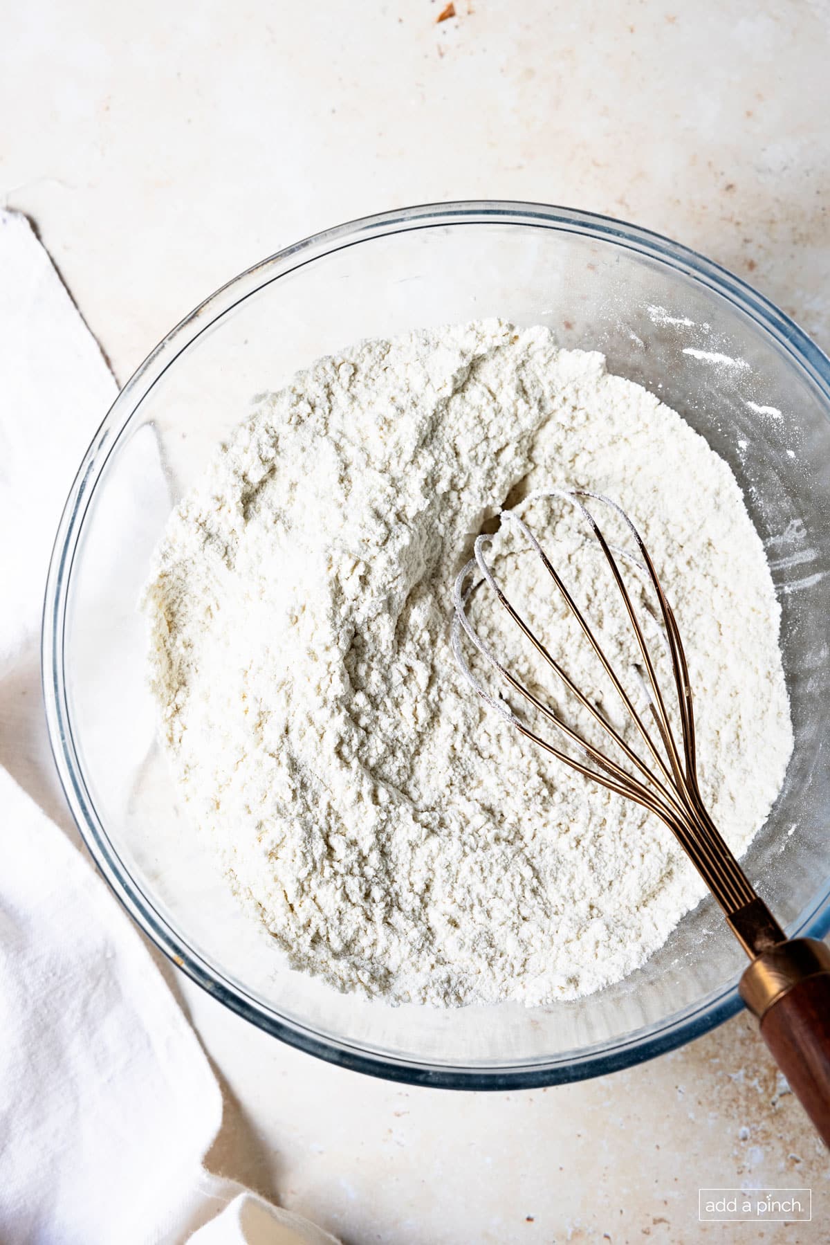 Photo of dry ingredients whisked together in a glass bowl.