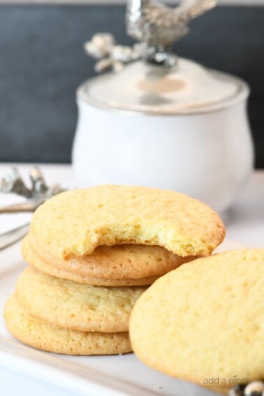 Photograph of stack of teacake cookies on a white platter. // addapinch.com