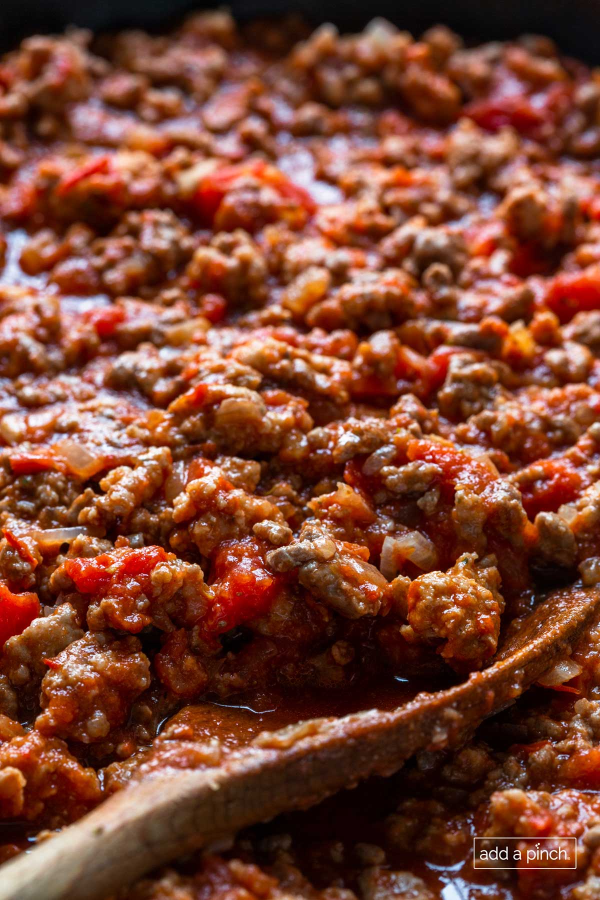 Closeup photo of homemade spaghetti sauce on a wooden spoon.