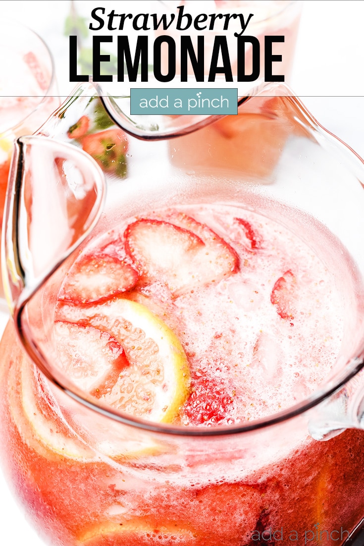 Strawberry Lemonade in glass pitcher and in glasses, garnished with strawberries and lemon slices - with text - addapinch.com