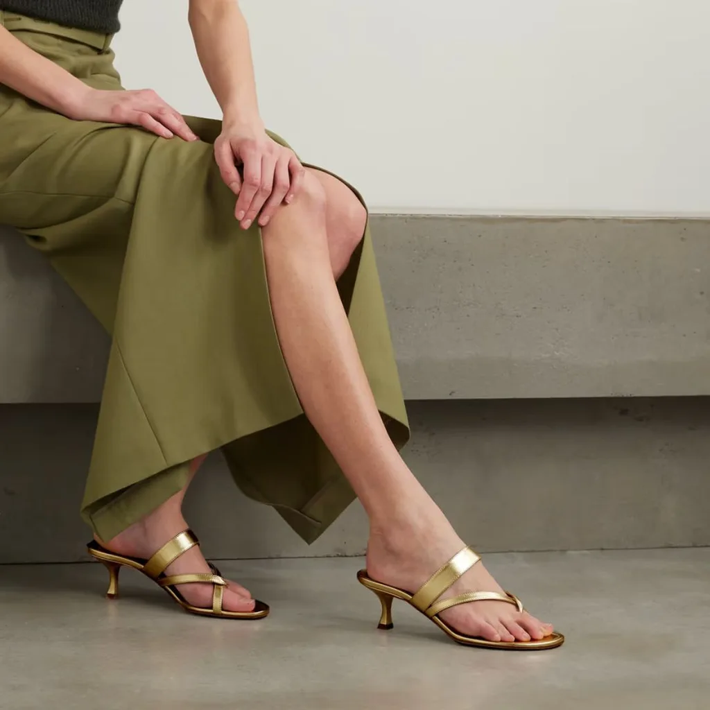 The Manolo Blahnik Susa 50 Leather Sandals are pure Carrie Bradshaw. The soft champagne gold leather features a top strap and a beautifully entwined "couble thong". The fluted stiletto heel is 2-inches.  