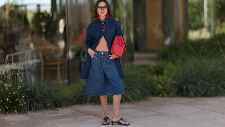 Guest at Copenhangen fashion week wearing all denim look with thong heels and a red bag.