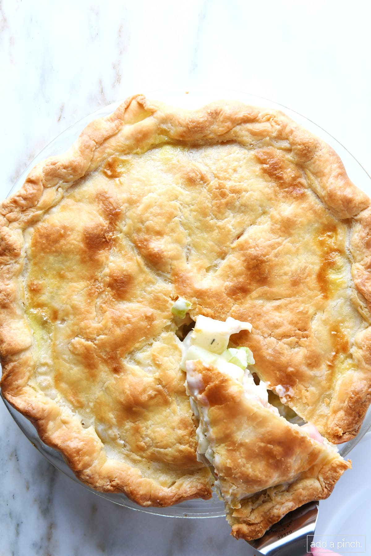 Turkey pot pie with a slice being removed.