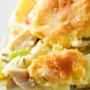 Slice of homemade turkey pot pie on a white plate with a fork.