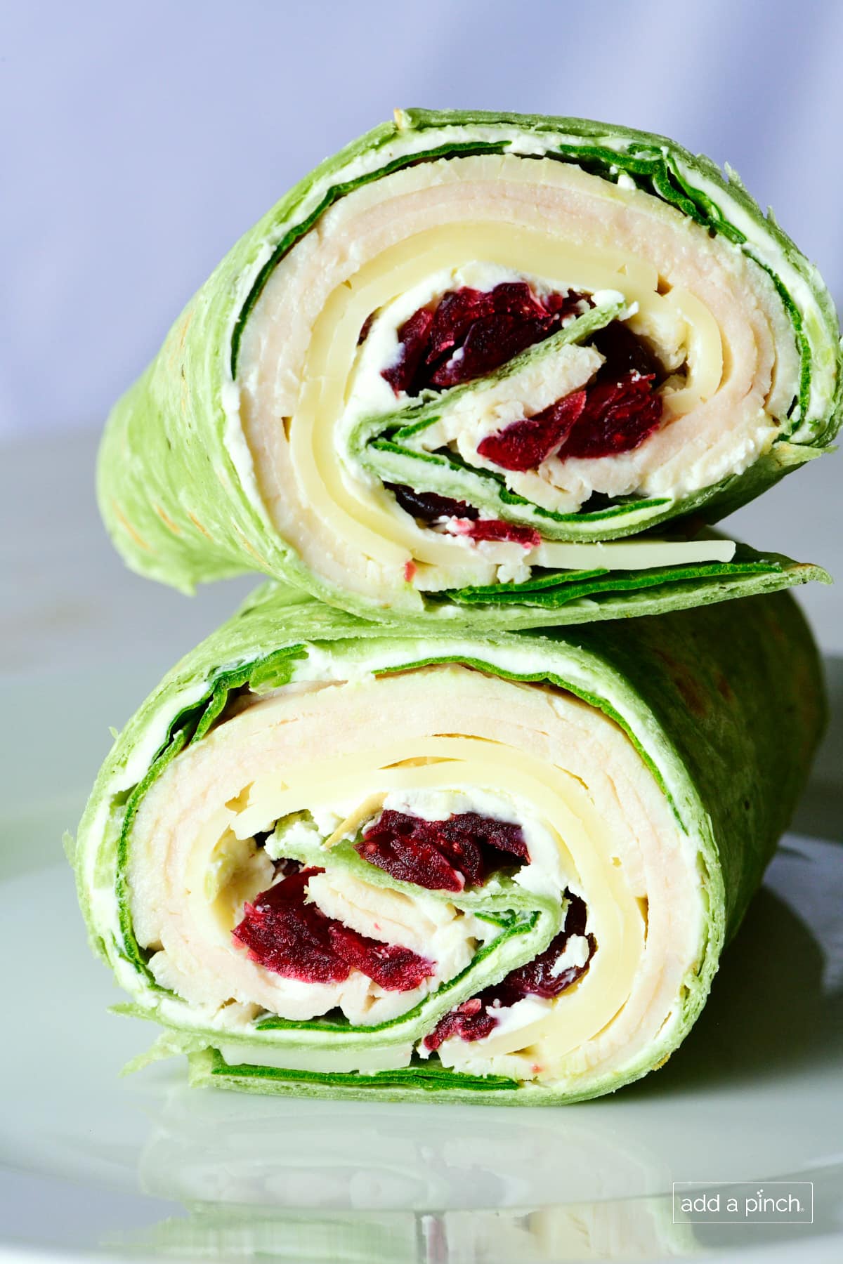 Turkey wraps on a white plate with white background.