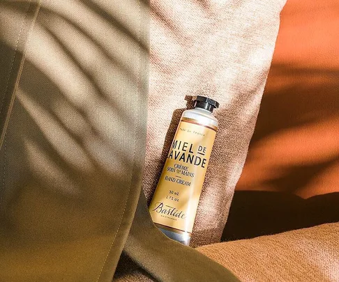 Tube of Bastide Miel de Lavande hand cream on a fabric surface with shadows.